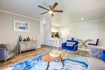 Apartments Henderson-Avalon at Seven Hills Open Floor Plan Living Room with Wood-Styled Floors and Large Windows